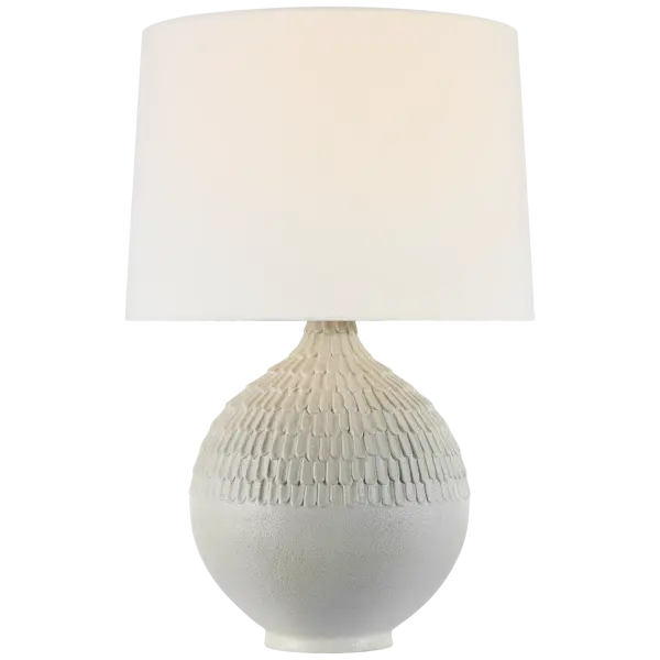 The Morava table lamp showcases exceptional hand-carved craftsmanship in a striking volcanic white finish. Its organic texture and sculptural base create visual interest while the linen shade provides warm, diffused light. - alternate view