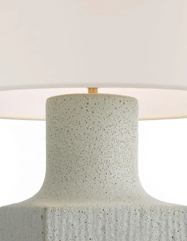 The Aviva 24" table lamp combines sophisticated ceramic craftsmanship with a soft volcanic ivory finish and natural linen shade. Its transitional design bridges traditional and contemporary aesthetics, making it versatile for bedrooms, living spaces, and hospitality settings. - alternate view