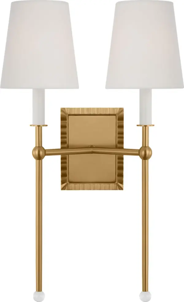 The Baxley wall sconce by Alexa Hampton masterfully blends traditional elegance with modern design elements. Its distinctive exaggerated stem topped with a crystal ball creates visual interest, while the burnished brass finish adds warmth.