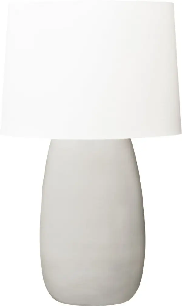 The Roma Table Lamp by Barbara Barry combines timeless elegance with modern sensibility. Its elongated oval ceramic base in Shellish Gray paired with a tailored linen shade creates warm, diffused lighting perfect for refined interiors.