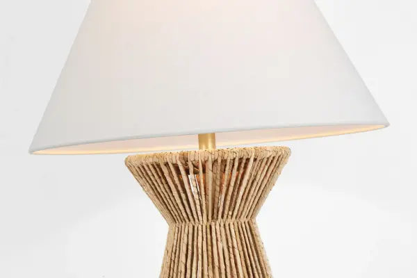 The Antigua table lamp brings organic coastal elegance with its natural abaca woven base and antique-burnished brass details. At 30" tall, it makes a sophisticated statement while the neutral linen shade provides warm, diffused light. - alternate view