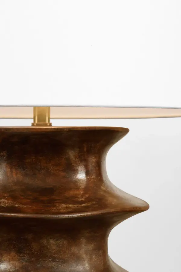 The Eldin table lamp combines a rich smoked umber finish with a classic linen shade, creating a versatile lighting solution that bridges traditional and contemporary design. At 28" tall, it provides substantial presence without overwhelming spaces. - alternate view