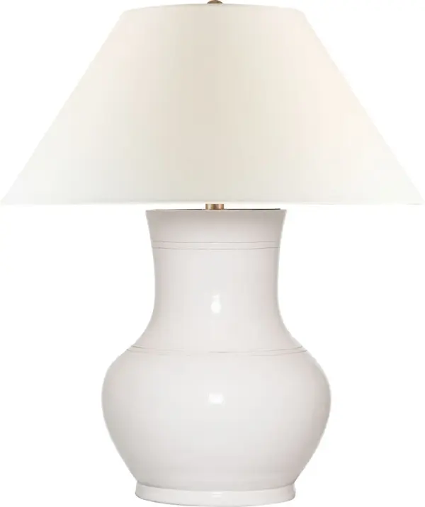 The Sorrento table lamp combines a distinctive glossy white crackle ceramic base with a classic linen shade, creating a refined transitional piece that bridges traditional and contemporary aesthetics with coastal charm.