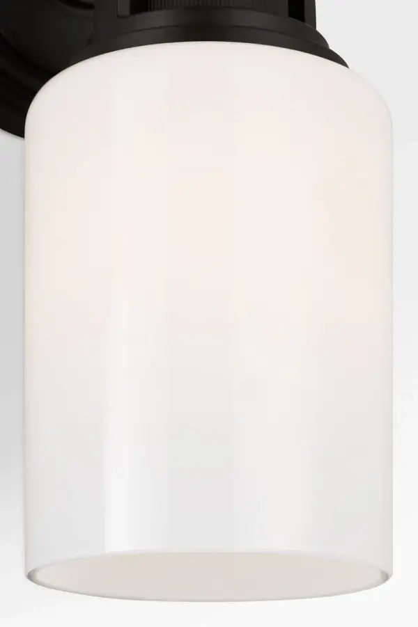 The Ashford 11" brings sophisticated industrial style to smaller bath spaces with its square arch bracket, circular collar, and vertically knurled socket detail. White cylindrical glass provides clean illumination while the open collar design allows upward light distribution. - alternate view