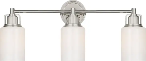 The Ashford 24" vanity light combines industrial precision with refined simplicity, featuring dual white cylindrical glass shades and vertically knurled socket covers that echo popular bath fittings.
