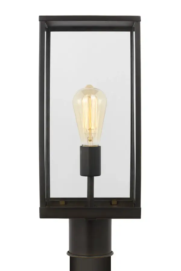 The Howell Medium Post Lantern combines timeless design with modern sensibility. Its clean rectangular frame and clear glass panels showcase a warm filament bulb, while the Antique Bronze finish adds sophistication to pathways and entryways. - alternate view