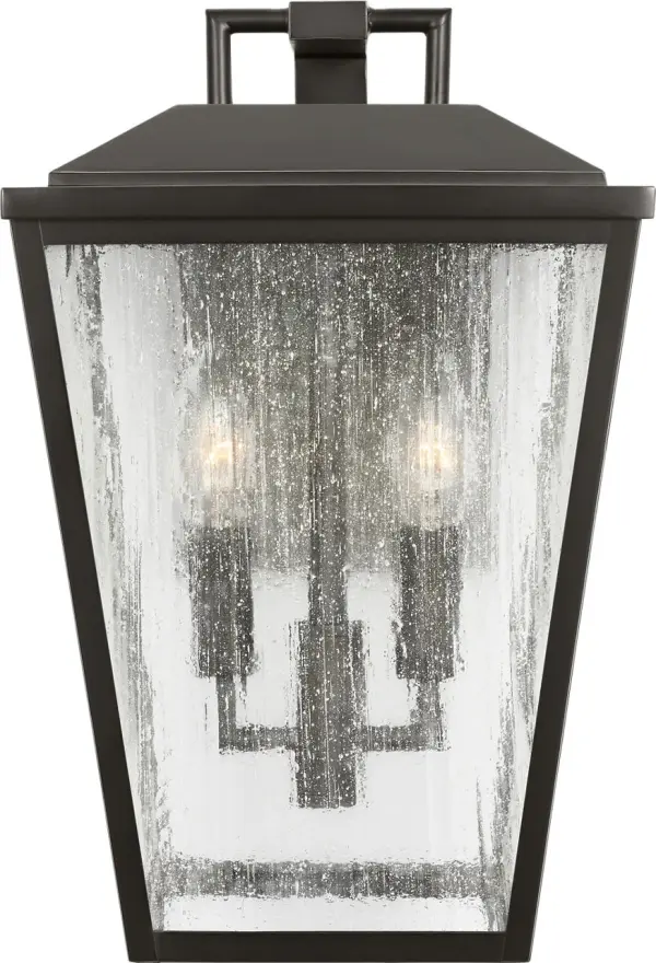 The Kennewick Medium Wall Lantern combines traditional design with durable outdoor construction. Its antique bronze finish and clear glass panels create welcoming illumination for entryways and exterior spaces.