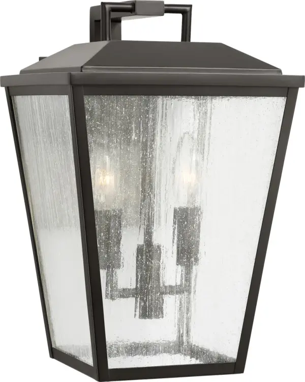 The Kennewick Medium Wall Lantern combines traditional design with durable outdoor construction. Its antique bronze finish and clear glass panels create welcoming illumination for entryways and exterior spaces. - alternate view