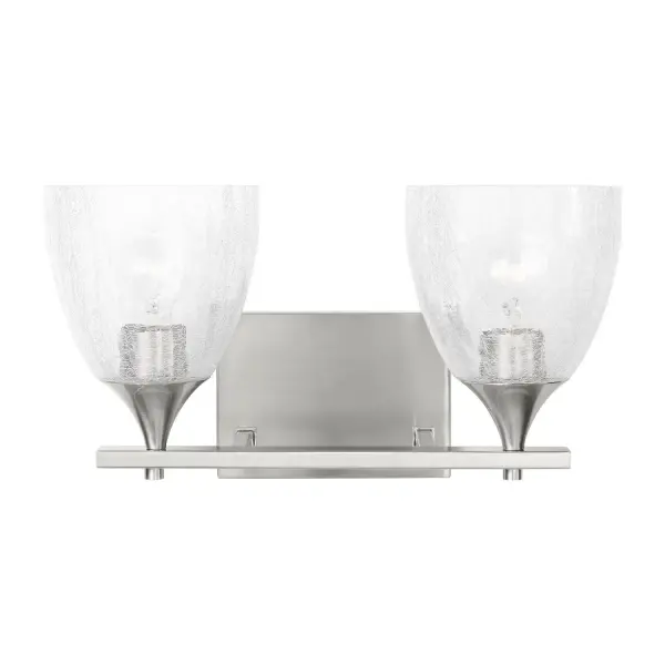 The Toffino vanity light by Drew & Jonathan Scott brings contemporary flair to traditional bath lighting with its unique crackle glass shades and versatile brushed nickel finish. Reversible mounting and damp location rating make it adaptable.