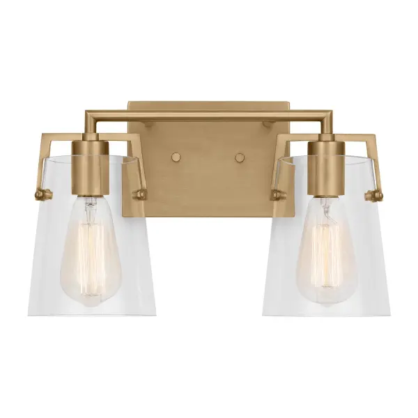 Drew & Jonathan's Crofton sconce delivers clean-lined style with practical functionality. The satin brass finish and clear glass shades create a warm, sophisticated look that works across traditional and contemporary settings.