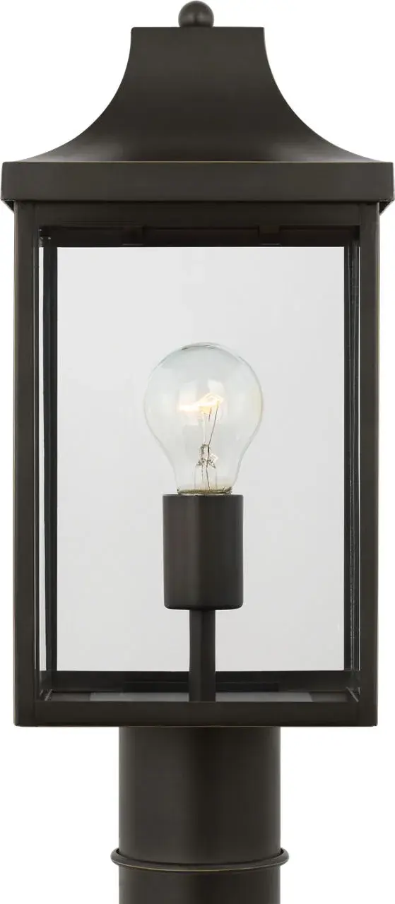 The Saybrook Medium Post Lantern combines traditional design with durable outdoor construction. Its antique bronze finish and clear glass panels create welcoming illumination for entryways and pathways. - alternate view