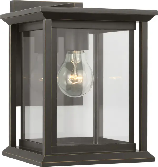 The Audley Small Wall Lantern delivers classic lantern styling in a space-conscious design. Its single-bulb configuration and clear glass panels provide functional illumination while the antique bronze finish adds timeless appeal to entries, columns, and secondary outdoor walls. - alternate view