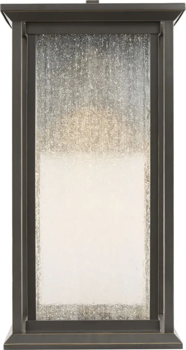 The Audley Medium Lantern blends traditional lantern styling with modern LED efficiency. Its distressed seeded glass creates soft, diffused light while the weather-resistant antique bronze finish ensures durability. Dark Sky Compliant and wet-rated for reliable outdoor performance. - alternate view