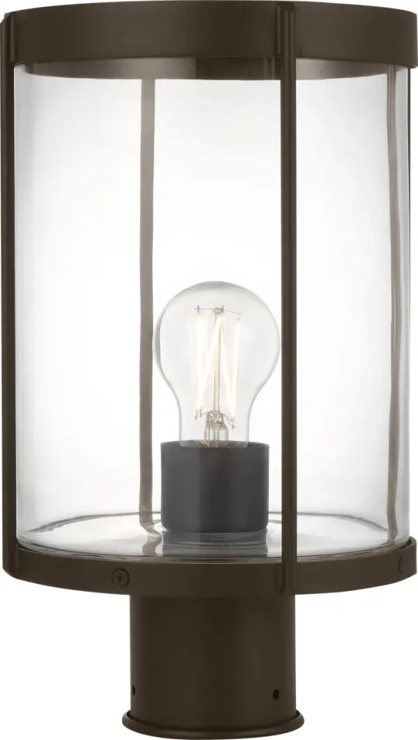 The Luning post lantern combines industrial elegance with outdoor durability. Its rounded metal frame and clear cylindrical glass shade create a subtle, welcoming glow perfect for pathways and entryways.
