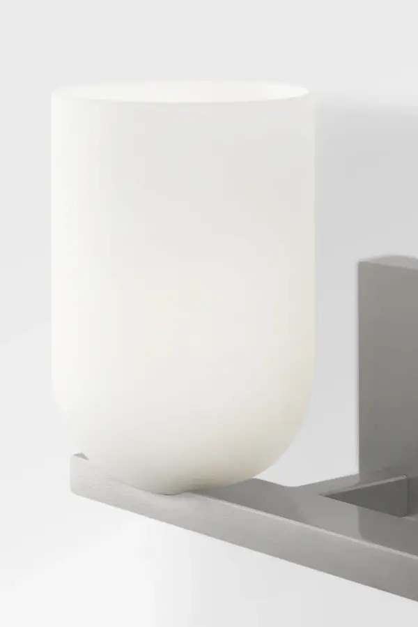 The Neblina vanity fixture combines quiet geometric design with frosted glass domes for diffused, flattering light. Perfect for bathrooms and powder rooms, its brushed nickel finish and clean lines adapt to both traditional and contemporary spaces. - alternate view