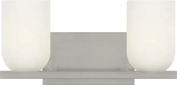 The Neblina vanity fixture combines quiet geometric design with frosted glass domes for diffused, flattering light. Perfect for bathrooms and powder rooms, its brushed nickel finish and clean lines adapt to both traditional and contemporary spaces.