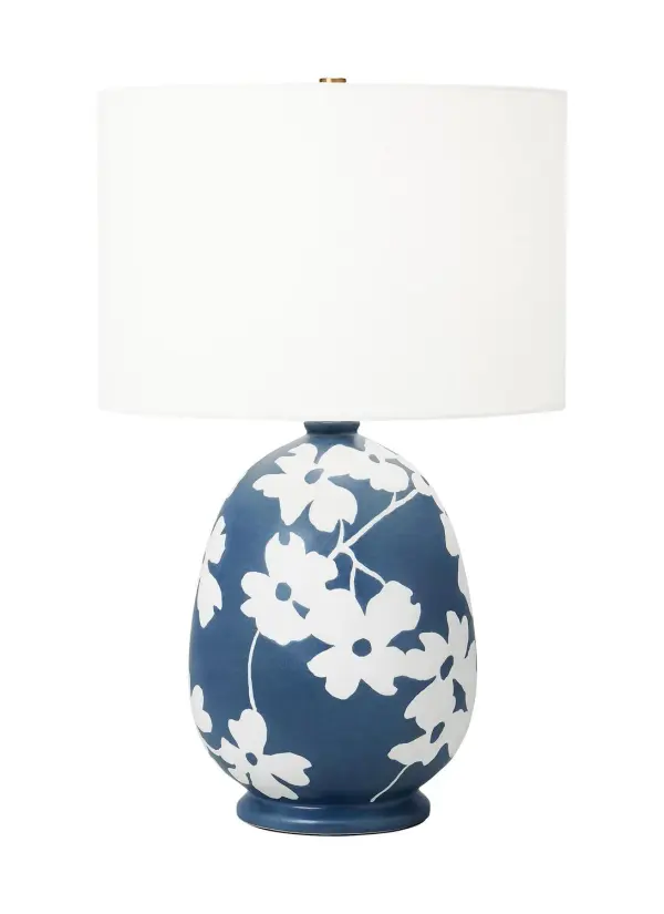 The Lila table lamp by Hable draws inspiration from Dogwood trails in East Texas, featuring a joyful floral ceramic base in semi-matte navy blue. The white linen shade softens the light while the feminine design adds personality without overwhelming.