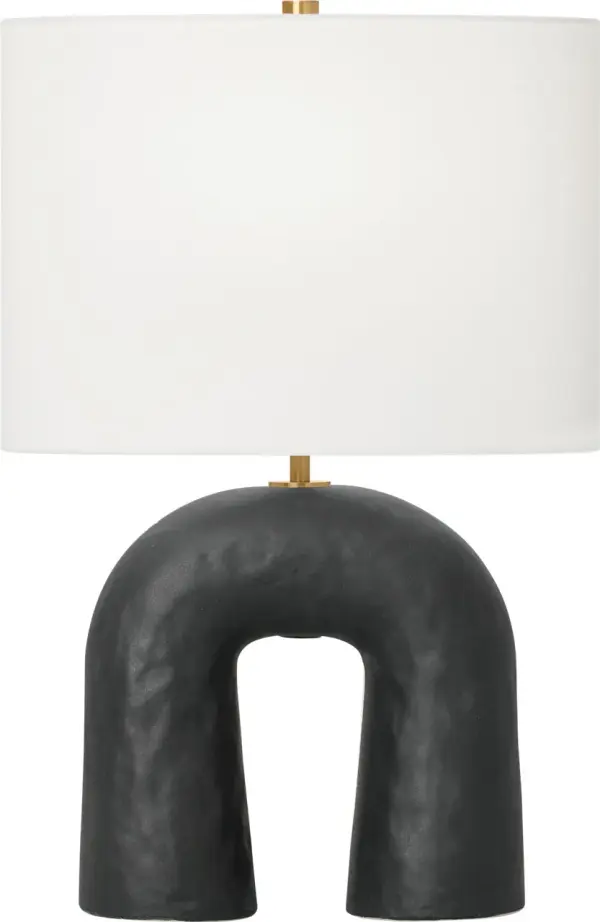 The Aura Small Table Lamp combines artisanal craftsmanship with contemporary design. Its hand-sculpted ceramic base features organic curves and tactile texture, complemented by brass accents and a white linen shade for soft, ambient lighting. - alternate view
