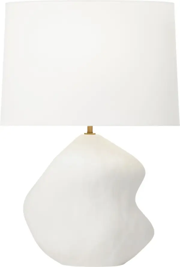 The Broxton Medium Table Lamp by Hable combines organic ceramic artistry with refined brass accents and a crisp linen shade. Its fluid, curving form creates a striking focal point while delivering soft, ambient lighting. - alternate view