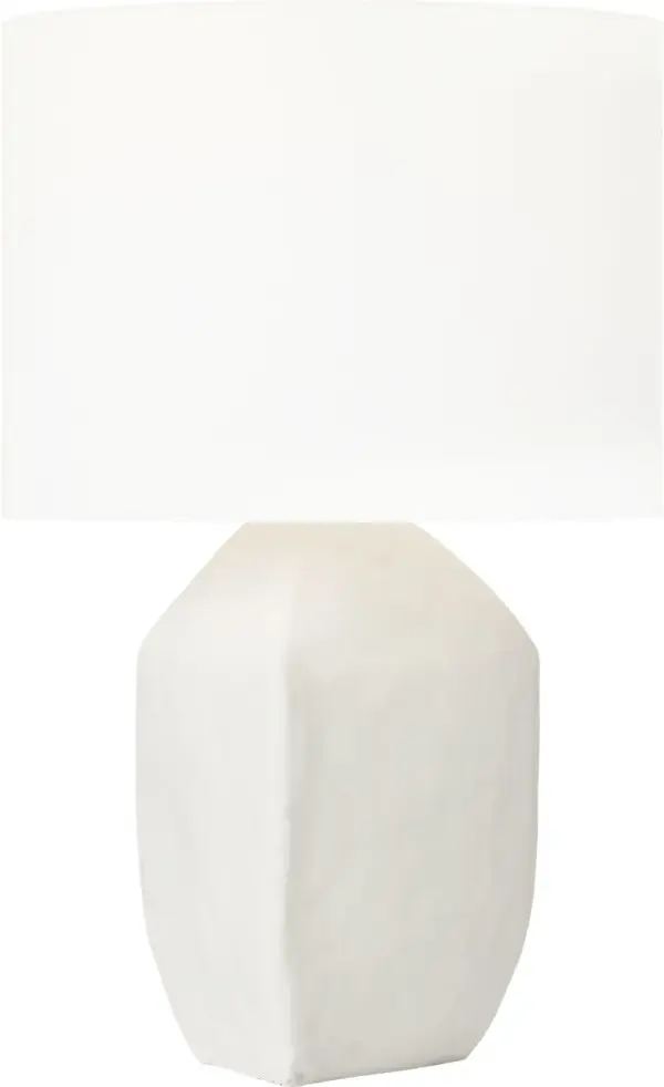 The Sybert Medium Table Lamp combines handcrafted artistry with contemporary design. Its distinctive angular ceramic base and white linen drum shade create a refined focal point that elevates any interior with soft, welcoming illumination. - alternate view