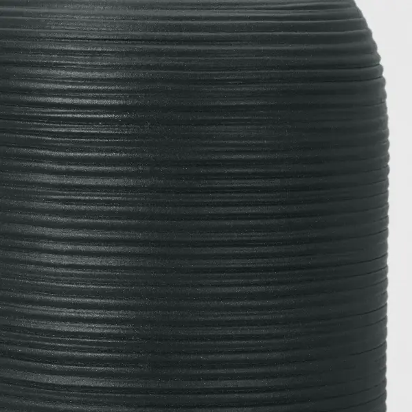 The Fanny Small Table Lamp features a distinctive rough black ceramic finish that adds tactile interest and contemporary style. Its compact size makes it perfect for layered lighting in bedrooms and living spaces. - alternate view