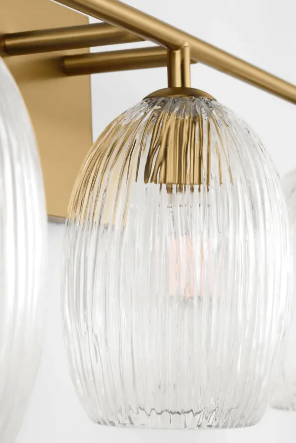 The Serafina 27" Bath Vanity Light brings organic sophistication to any space with its combed glass shades inspired by dried ceramics and botanical forms. The burnished brass finish adds warmth while the textured glass diffuses soft, ambient light. - alternate view