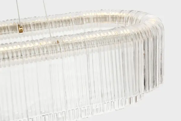 The Maderno linear chandelier commands attention with its impressive 55-inch span and hand-rubbed antique brass finish. Clear glass shades provide brilliant illumination while the substantial scale makes it perfect for large dining rooms and kitchen islands. - alternate view