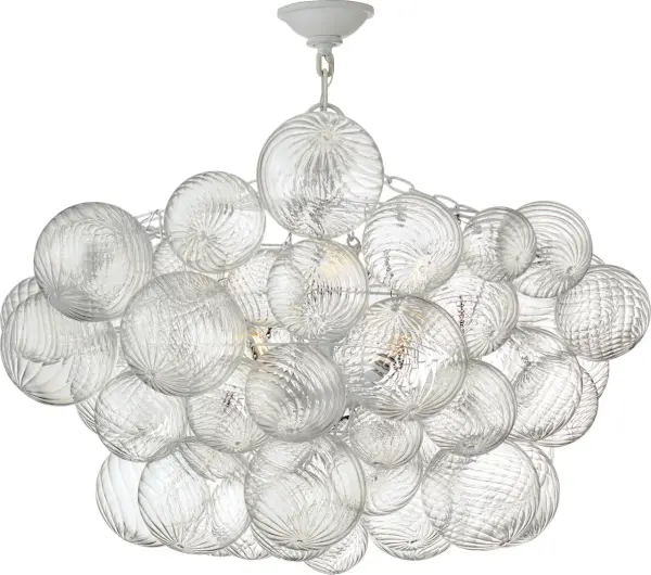 The Talia semi-flush mount by Julie Neill transforms the classic glass globe into an artful statement piece. Multiple swirled glass orbs in metal baskets create shimmering light play with a feminine, playful touch.