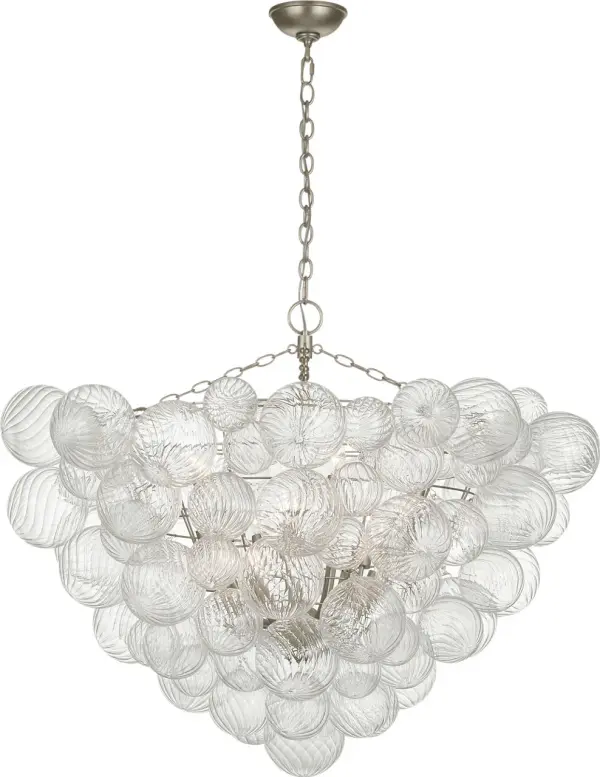 The Talia chandelier by Julie Neill combines artisanal swirled glass orbs with burnished silver leaf metalwork for a sophisticated yet playful statement piece. At 46 inches, it's perfectly scaled for larger dining rooms and entryways.