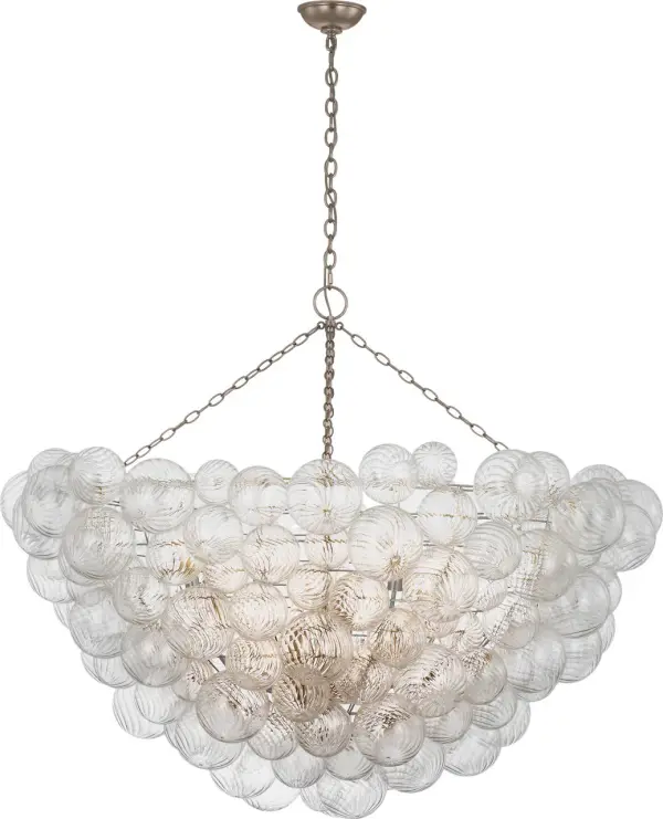 The Talia 56" chandelier by Julie Neill transforms the classic glass globe fixture with swirled artisanal glass orbs set in metal baskets. Its substantial 56-inch length makes a dramatic statement while maintaining feminine, playful charm.