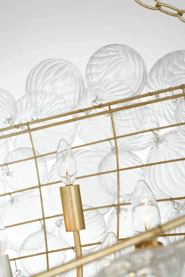 The Talia 66" chandelier by Julie Neill transforms grand spaces with its whimsical arrangement of swirled glass orbs in metal baskets. The burnished silver leaf finish adds sophisticated sparkle while the artisanal glass creates dynamic light play. - alternate view