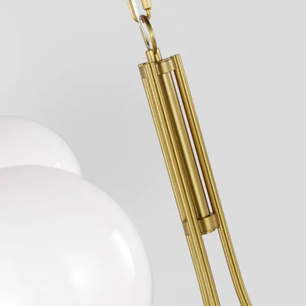 The Noemie Medium Chandelier combines classic mid-century design with modern sophistication. Three smooth milk glass orbs are gracefully suspended by curved Burnished Brass arms, creating refined visual balance and warm, luminous ambiance. - alternate view