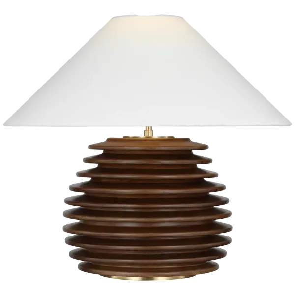 The Crenelle table lamp features a distinctive stacked wood construction in burnished birch, creating architectural interest with natural texture. The 20-inch height and linen shade provide warm, diffused lighting ideal for living spaces. - alternate view