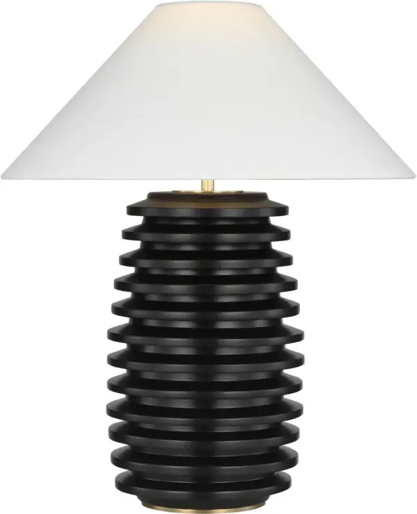 The Crenelle table lamp showcases architectural stacked wood construction in rich ebonized birch, creating visual interest through geometric layering. The natural linen shade softens the dramatic dark finish, making it versatile for both traditional and contemporary interiors.