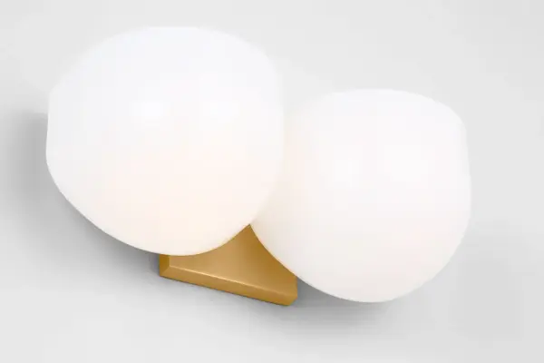 The Cheverny Medium Vanity by Christiane Lemieux combines refined aesthetics with practical illumination. Two rounded milk glass shades provide balanced, flattering light while the burnished brass finish adds warmth and luxury to bathroom spaces. - alternate view