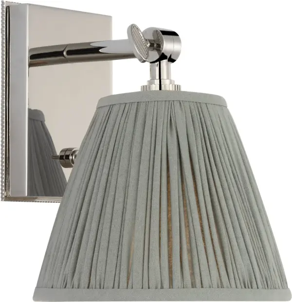 The Wimberley Bedside Wall Light combines timeless polished nickel hardware with a sophisticated blue linen pleated shade, offering both functional task lighting and decorative appeal for bedrooms and hospitality spaces.