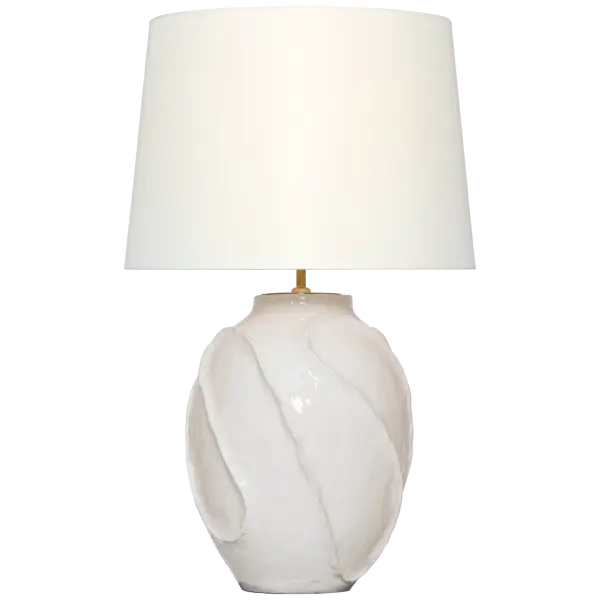 The Idalia table lamp features a distinctive sculpted ceramic base with a glossy white crackle finish that adds textural interest and coastal charm. At 28" tall with a linen shade, it provides sophisticated ambient lighting for bedrooms and living spaces.
