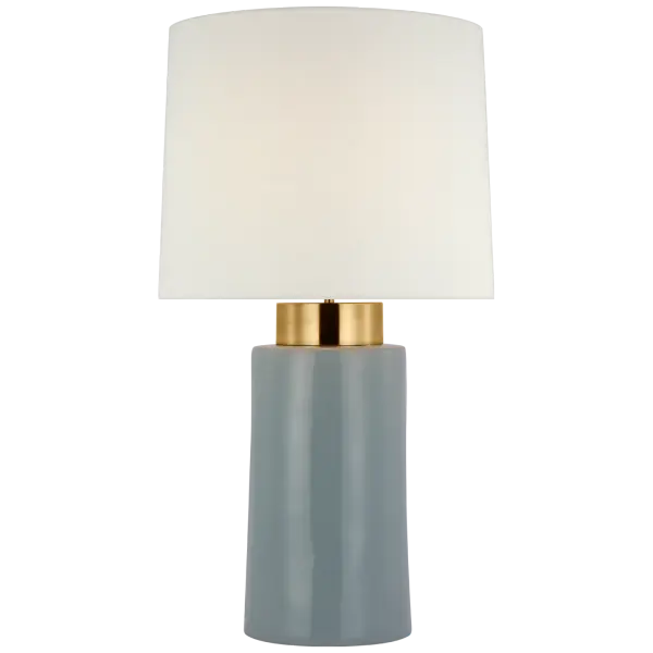The Xian table lamp combines sky gray and soft brass finishes for a refined transitional aesthetic. At 30" tall, it provides substantial presence with a classic linen shade that diffuses light beautifully.