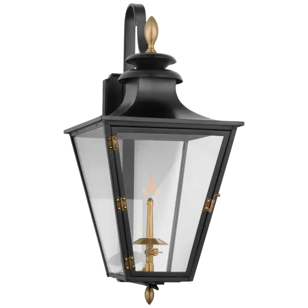 The Albermarle Small Wall Lantern combines traditional gas lantern styling with a modern matte black and brass finish. Clear glass panels showcase the flame while the bracketed design adds architectural interest to any exterior.