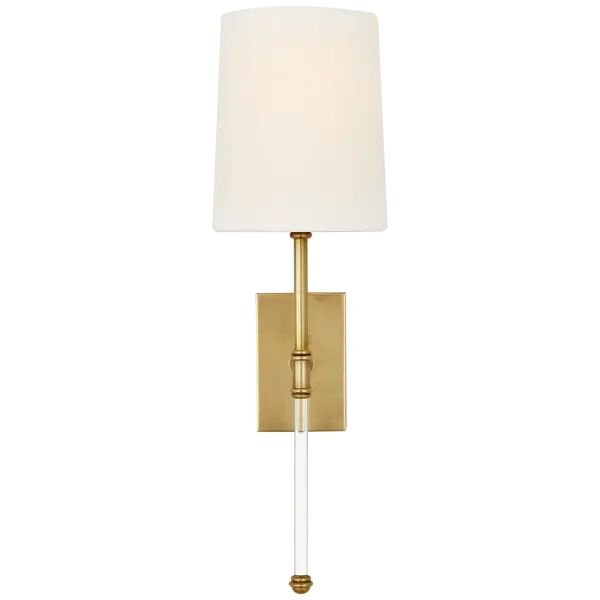 The Camille 16" sconce combines hand-rubbed antique brass with a classic linen shade for sophisticated ambient lighting. Its transitional design bridges traditional and contemporary aesthetics, making it versatile for various interiors.