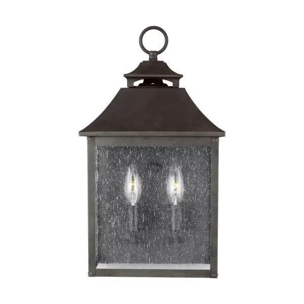 The Galena wall lantern brings timeless elegance to outdoor spaces with its Europe-inspired design. Featuring a gently curved hook detail, vented roofline, and floating candle tubes within tapered clear glass, it delivers both beauty and function.