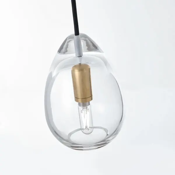 The Alina Pendant combines artisanal European craftsmanship with contemporary design. Its hand-blown teardrop silhouette and natural brass hardware create a sophisticated focal point that works beautifully in multiples or as a standalone accent. - alternate view