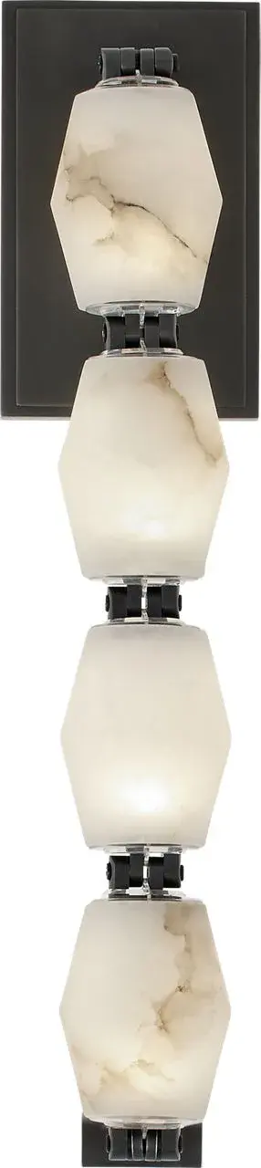 The Collier sconce combines natural alabaster with a rich bronze finish, creating sophisticated ambient lighting. At 15 inches, it provides substantial presence while maintaining refined proportions for various spaces.