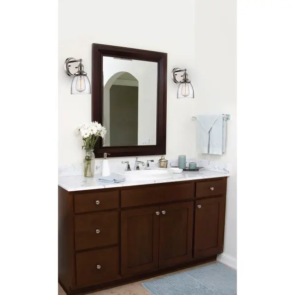 This polished nickel wall sconce combines contemporary styling with vintage appeal through its exposed ST19 bulb and clear glass shade. The up-or-down mounting flexibility makes it adaptable for various spaces. - alternate view