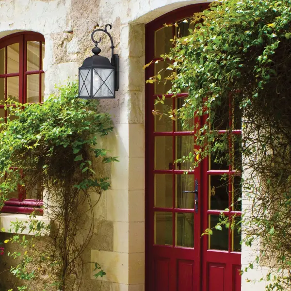 The Wingate outdoor wall fixture combines contemporary style with classic charm. Its textured black finish and clear seeded glass create visual interest while providing reliable illumination for entryways, porches, and pathways. - alternate view