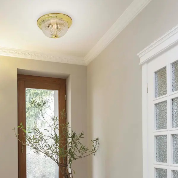 This sophisticated 11-inch flush mount combines traditional polished brass with textured clear ribbed glass for timeless elegance. Perfect for rooms with standard ceiling heights, it provides ample illumination while adding refined style. - alternate view