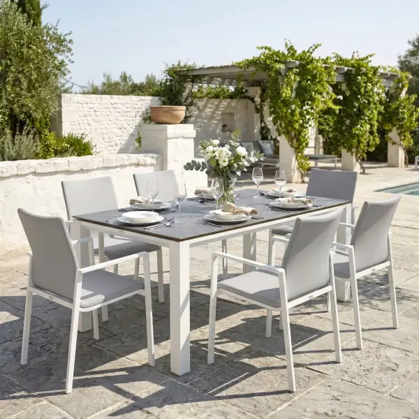 Dine alfresco in style with the Sense Dining Set. The sleek profile of the table and chairs give a clean, contemporary look. The dining chairs feature an aluminum frame with ergonomic arm rests and a comfortable all-weather sling with quick dry foam filling and all weather upholstery fabric. The ceramic top, aluminum frame table is sturdy and weather resistant, ensuring years of outdoor dining enjoyment. Set Includes: (6) Sense Dining Arm Chair (1) 71” x 36” Concept Dining Table Sense Dining Chair Features: Light-weight powder coated aluminum construction All weather soft touch Textilene fabric cushion for optimal weather resistance and color fastness Padded seat-buckets for maximum comfort and support Durable, all-weather frame and fabric construction Protective, replaceable foot caps prevent marring on any surface and extends the life of the chair No assembly needed Stackable for compact, easy storage Frame color: White Measures: 23"W x 23"D x 34"H, 10lbs Fabric Color: Mouse Grey 71" x 36" Ceramic Dining Table Features: Sturdy powder coated aluminum construction with stainless steel hardware Maintenance free ceramic table top is highly scratch resistant and withstand temperatures ranging from -40°F to 500°F Durable, all-weather frame construction Protective, replaceable foot glides prevent marring on any surface and prolong the life of the table Elegant style lines provide a modern look to any outdoor space Reinforced square frame tubing for added strength Integrated foot levelers prevent wobbling on uneven floors No umbrella hole Minimal assembly needed Measures: 71"L x 36"W x 30"H Frame color: White