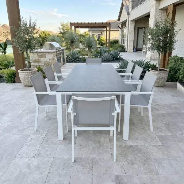 Elevate outdoor dining with the Primavera 9-Piece Dining Set, where refined design meets effortless durability. Eight ergonomically contoured sling chairs—crafted with lightweight, powder-coated aluminum frames and breathable, quick-drying acrylic Textilene—offer exceptional comfort, resilience, and stackable convenience, with optional Sunbrella cushions for an added layer of luxury. Paired with the Concept Dining Table, featuring a sleek ceramic top with a sophisticated concrete-look finish, this set delivers both modern elegance and remarkable performance in any climate. In a timeless white and mouse gray palette, Primavera creates a polished, inviting setting for everyday dining and elevated outdoor entertaining. Chair Features: Light-weight powder-coated aluminum construction with stainless steel hardware 100% Acrylic Textilene fabric sling for optimal weather resistance and color fastness Premium, quick-drying sling allows superior drainage Contoured seat and back for maximum comfort and support Frame features full circumference welds for added strength Durable, all-weather frame and fabric construction Integrated arm rests for additional comfort and style Protective, replaceable foot caps prevent marring on any surface and extend the life of the chair Stackable for compact, easy storage Frame | Sling Color: White/Mouse Gray Optional Sunbrella Cushion available in Grey Chine Fabric Table Features: Elegant style lines provide a modern look to any outdoor space Robust powder coated aluminum construction with stainless steel hardware Frame features full circumference welds for a durable, all-weather frame Durable ceramic top with concrete look finish can withstand temperatures ranging from -40°F to 500°F Durable, all-weather frame construction Protective, replaceable foot glides prevent marring on any surface and prolong the life of the table Integrated foot levelers prevent wobbling on uneven floors No umbrella hole Frame Color: White Top Color: Concrete Look