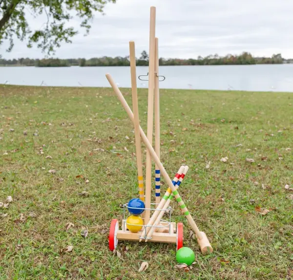 Complete 4-player croquet set featuring 32-inch wooden mallets, durable resin balls, and all necessary wickets and pegs. Includes convenient wheeled storage cart for easy transport and organization. - alternate view