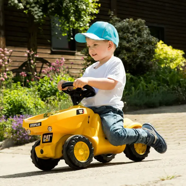 This CAT-branded ride-on toy combines durability with play value, featuring a working horn, storage compartment, and comfortable knee indention for scooting. Built from high-impact resin with quiet tires, it's designed for ages 18 months to 4 years. - alternate view